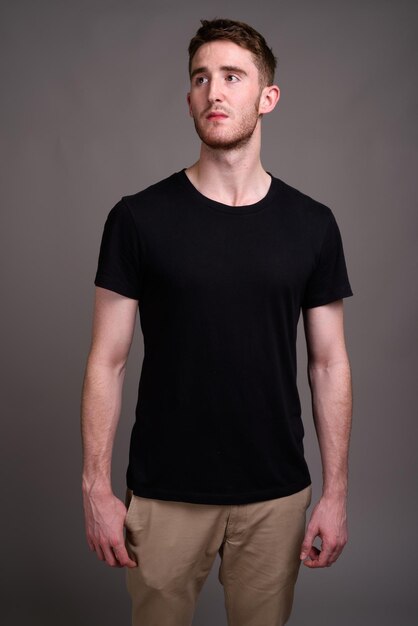 Photo portrait of young man standing against wall