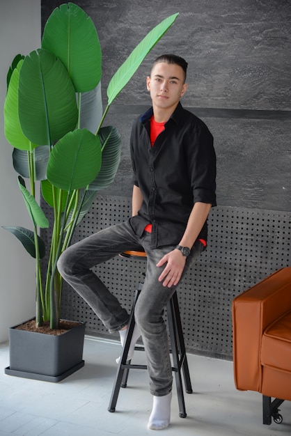 portrait of a young man in a stylish modern interior near the window