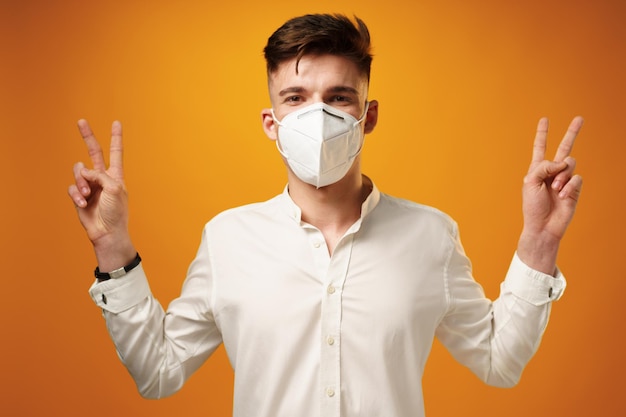 Portrait of a young man wearing face mask against yellow background