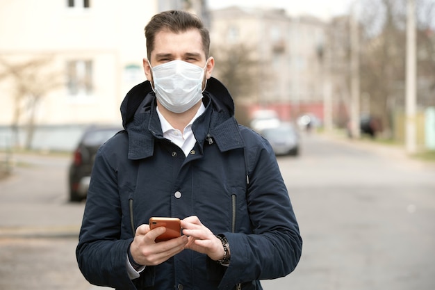 Portrait of a young man wearing protective mask on street