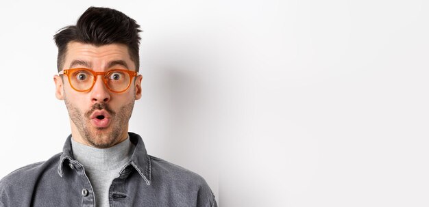 Portrait of young man wearing sunglasses against white background