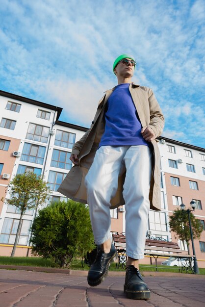 A portrait of a young man while looking up in the street