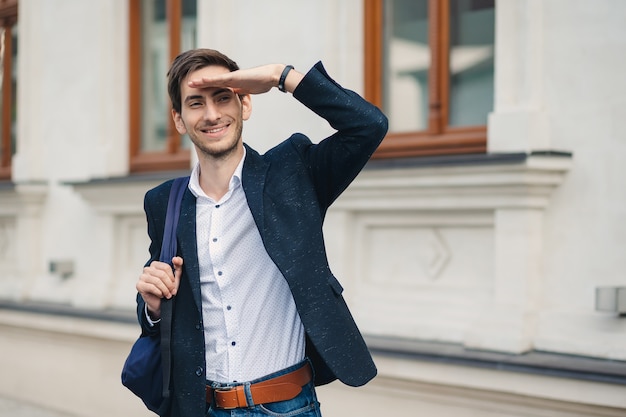 Portrait of young man with backpack who saw a friend