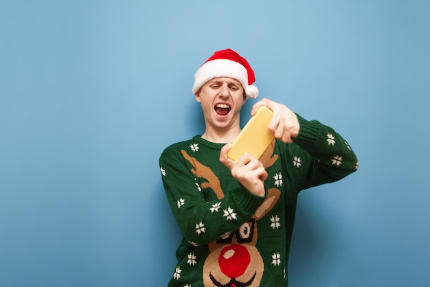 portrait young man with Christmas hat using phone