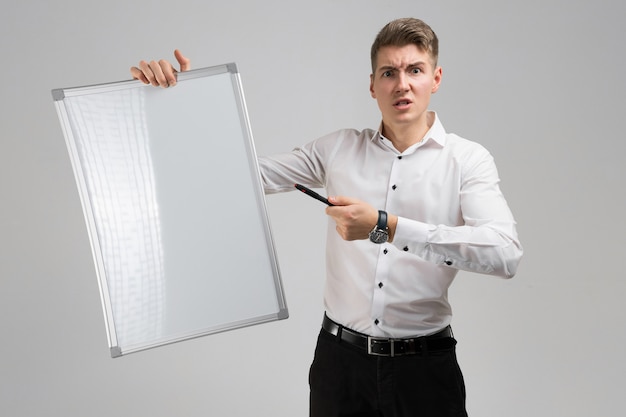 Portrait of young man with clean magnetic Board and marker in his hands