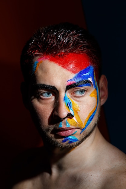 Portrait of a young man with colored paint