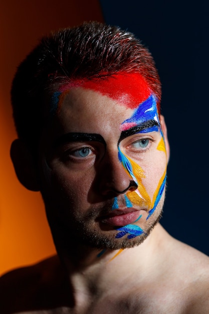 Portrait of a young man with colored paint