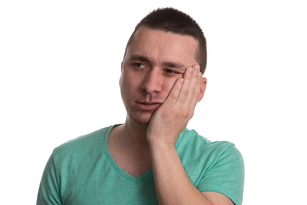 Portrait Of Young Man With Sensitive Tooth Ache Crown Problem  Suffering From Pain Touching Outside Mouth With Hand Isolated On White Background