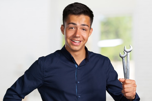 Portrait of a young mechanic holding a wrench