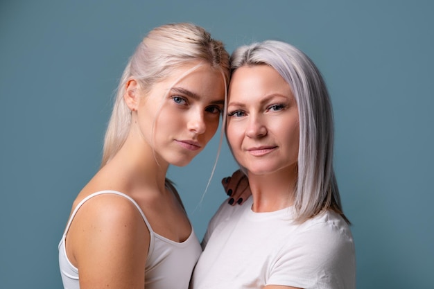 Portrait of young mother and daughter on blue background family concept