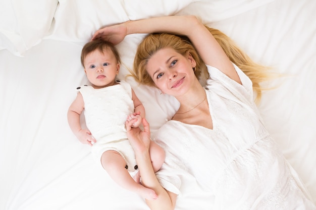 Portrait of young mother with blond hair with her sweet 3 month old baby girl