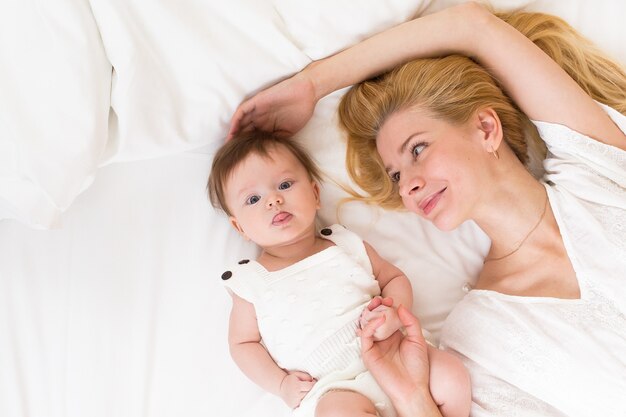 Portrait of young mother with blond hair with her sweet 3 month old baby girl