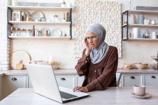 Portrait of a young muslim woman in a hijab who does not feel well feels a severe headache tension