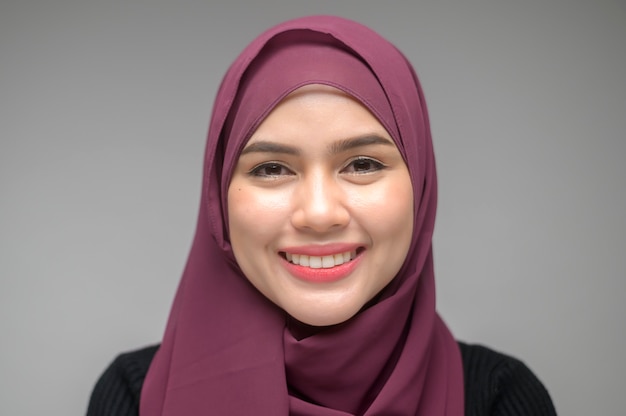 A portrait of young muslim woman over white background studio