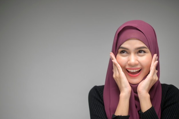 A portrait of young muslim woman over white background studio