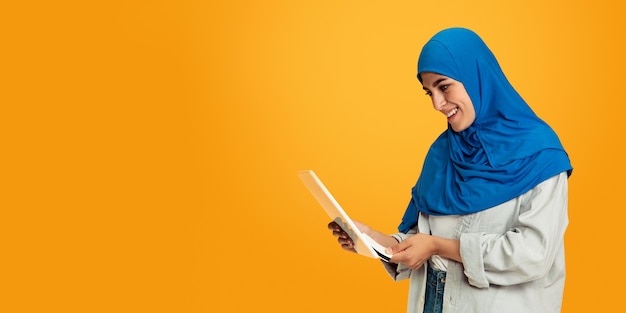 Portrait of young muslim woman on yellow wall