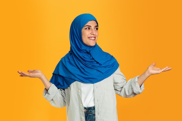 Portrait of young muslim woman on yellow