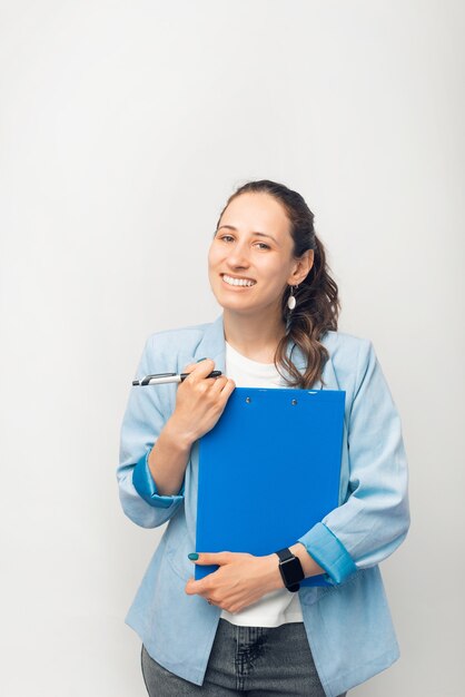 Portrait of young office woman worker holding paper work and smiling at the camera