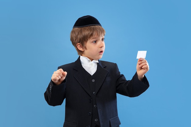 Portrait of a young orthodox jewish boy isolated on blue studio