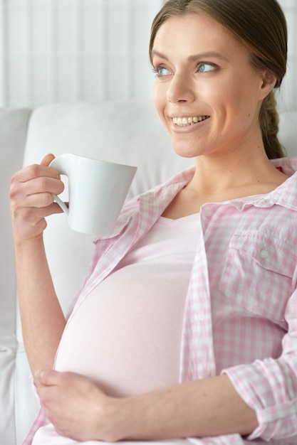 Portrait of a young pregnant woman, holding her tummy