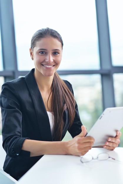 portrait of Young pretty business woman work on  notebook computer  in the bright modern office indoors