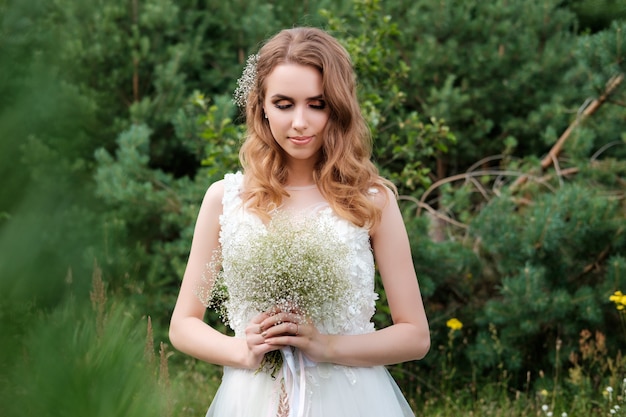 Portrait of young pretty woman (bride) in white wedding dress outdoors, hairstyle