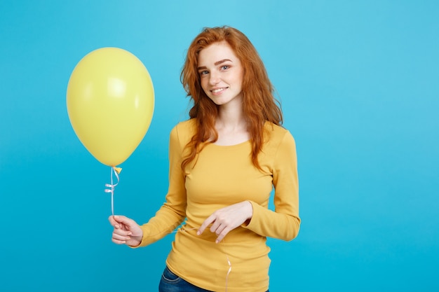 portrait young red hair girl with a yellow balloon.