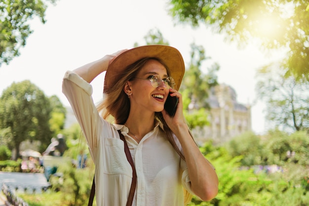 Portrait of a young singleminded blonde woman talking on the phone and walking around the city outdoors