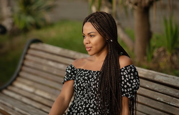 Portrait of a young smiling African woman with dreadlocked pigtails on her head.