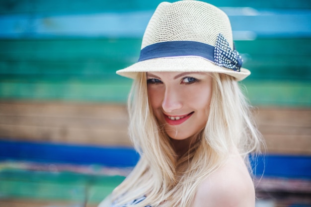 The portrait of young smiling blond woman in a hat