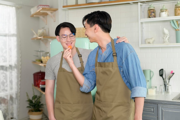 Portrait of young smiling gay couple in the kitchen at home LGBTQ and diversity concept