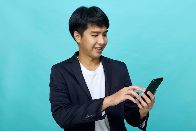 Portrait of a Young smiling handsome Asian man in a semiformal suit using a mobile phone