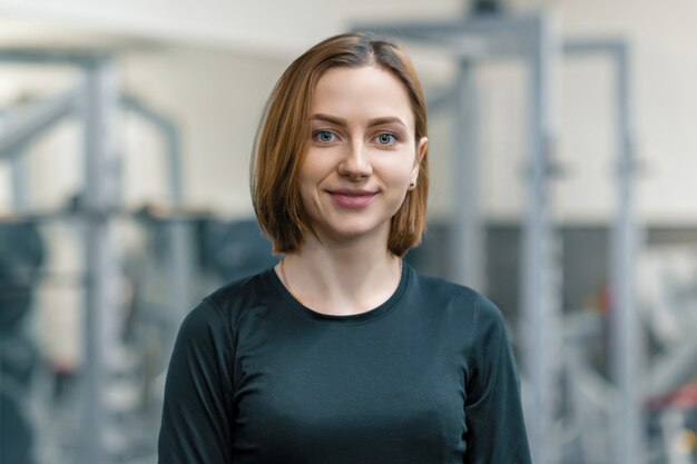 Portrait of young smiling woman in the gym