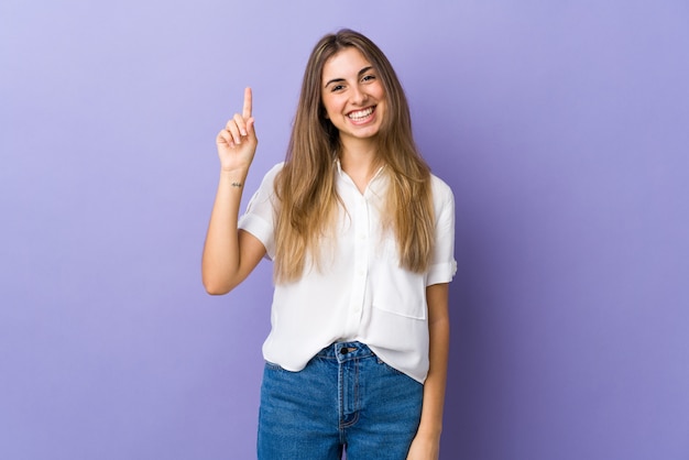 Portrait of a young smiling woman pointing up