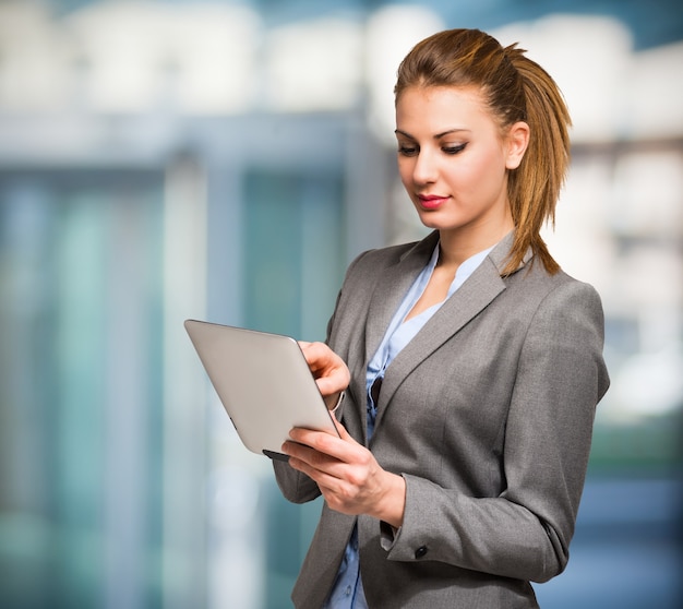 Portrait of a young smiling woman using a digital tablet