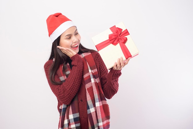 A portrait of young smiling woman wearing red Santa Claus hat isolated white background studio.