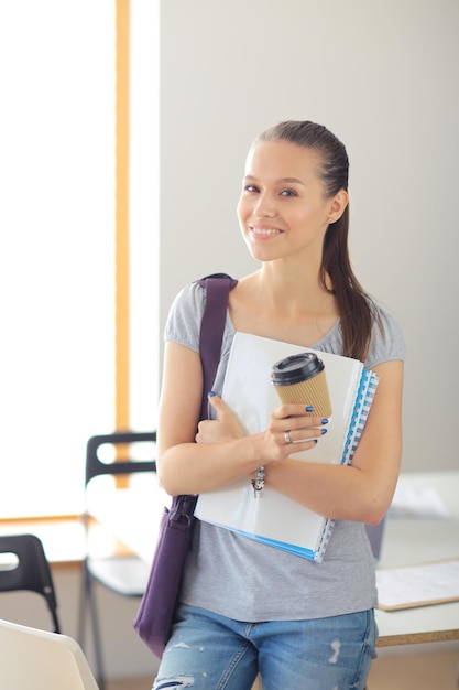 Portrait of young student woman holding exercise books Student woman