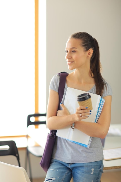 Portrait of young student woman holding exercise books Student woman