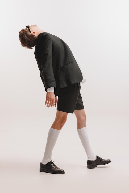 Portrait of young stylish man posing isolated over white studio background Model in black and white outfit