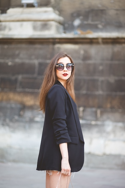 portrait of a young stylish woman on a city street