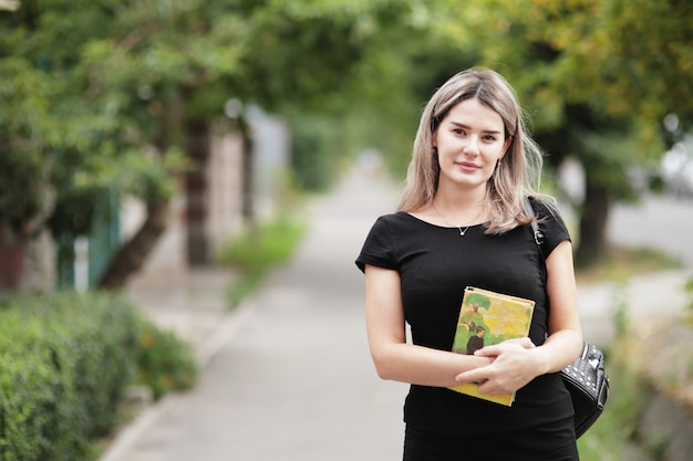 Portrait of young stylish woman walking down the street