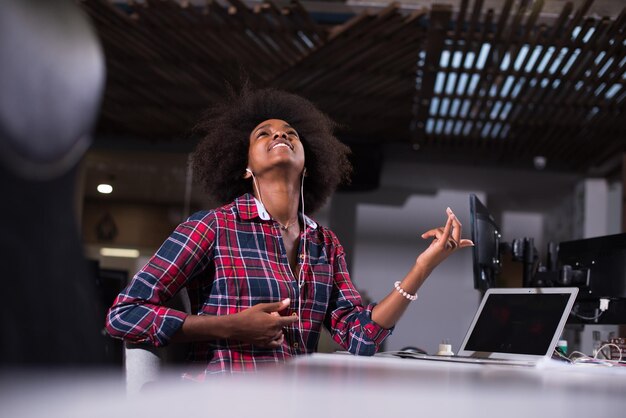 portrait of a young successful African American beautiful woman who enjoys spending a quality and joyful time while working in a large modern office