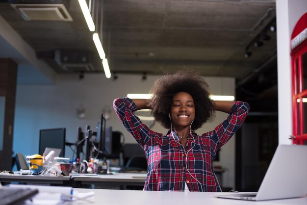 portrait of a young successful African American beautiful woman who enjoys spending a quality and joyful time while working in a large modern office