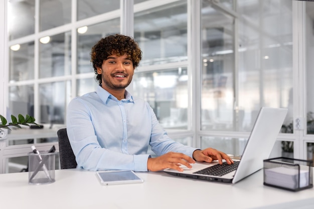 Portrait of young successful contemporary businessman inside office man at workplace smiling and