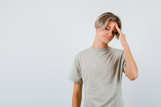 Portrait of young teen boy rubbing forehead