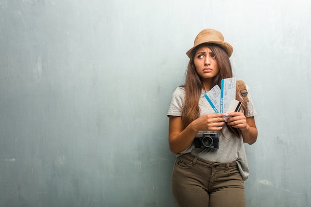 Portrait of young traveler latin woman against a wall very scared and afraid, desperate for something