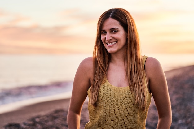 Portrait of a young woman on the beach at sunset