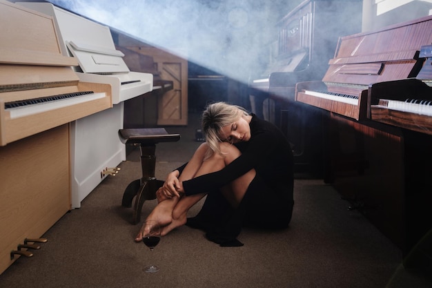 Portrait of a Young Woman in Black Dress Amidst Pianos in a Warehouse