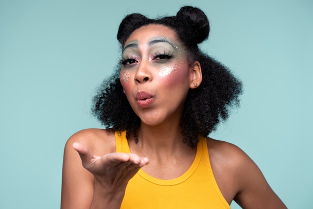 Portrait of a young woman blowing a kiss and wearing make-up