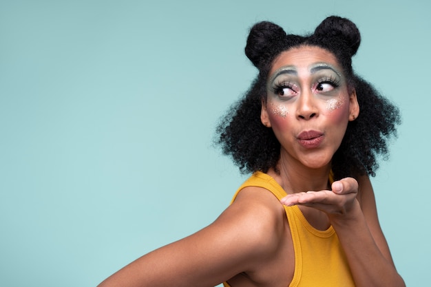 Portrait of a young woman blowing a kiss and wearing make-up